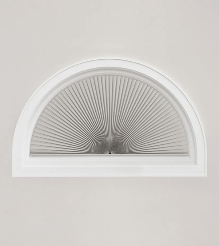 A fan fold honeycomb shade in an arched window