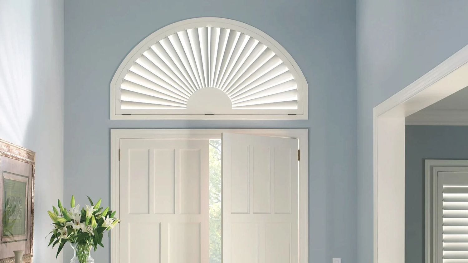 A sunburst arch shutter over a pair of French doors