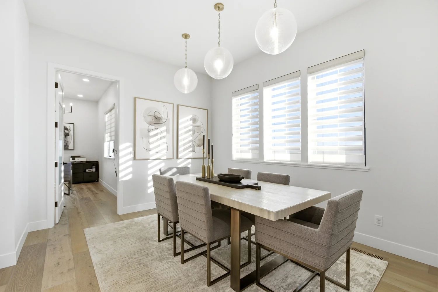 A bright dining room with custom window treatments on three windows