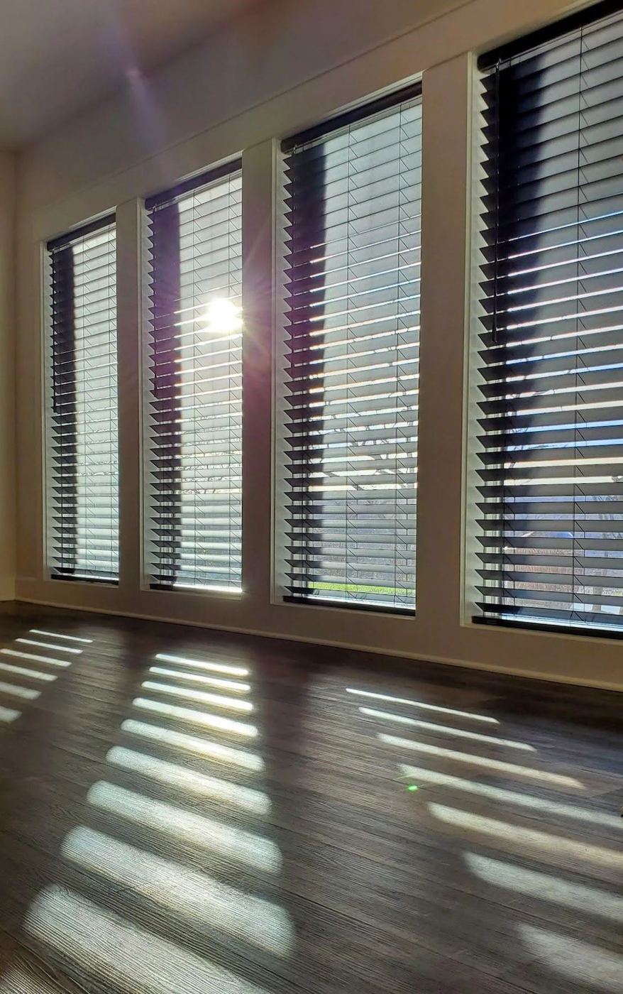 Dark blinds with afternoon sun striping the floor