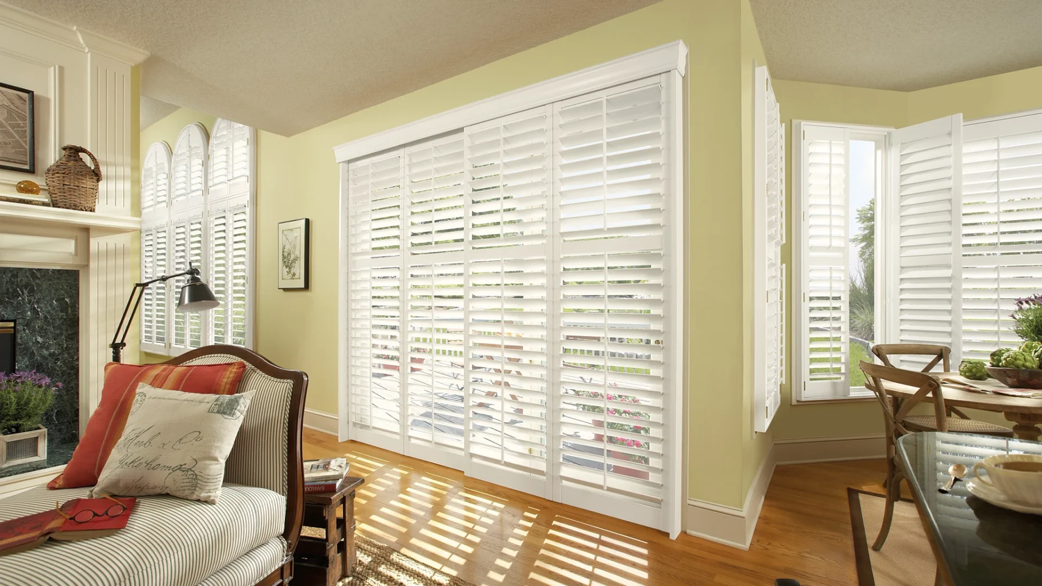 White composite shutters on a patio door and bay window